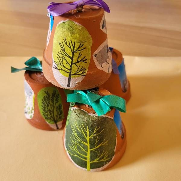 aufeinandergestapelte und bemalte Tontöpfe mit Serviettentechnik